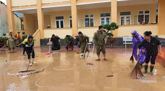 Hàng trăm cảnh sát cơ động xắn tay dọn bùn phủ kín sân trường học